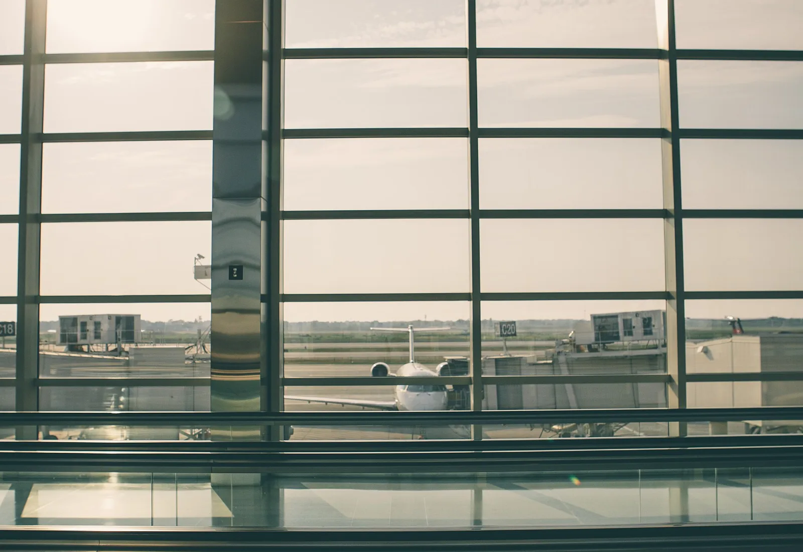 An aeroplane at the gate, seen through an airport terminal window